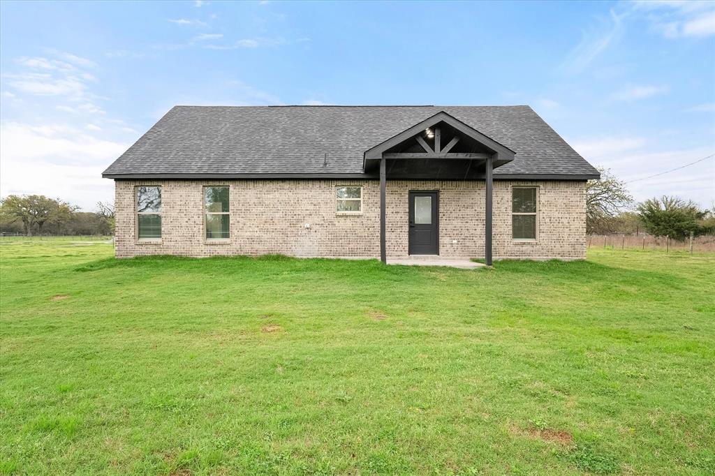 6771 Northwest County Road 1146 Barry, TX 75102 - Photo 31 of 34 a front view of a house with a yard and garage