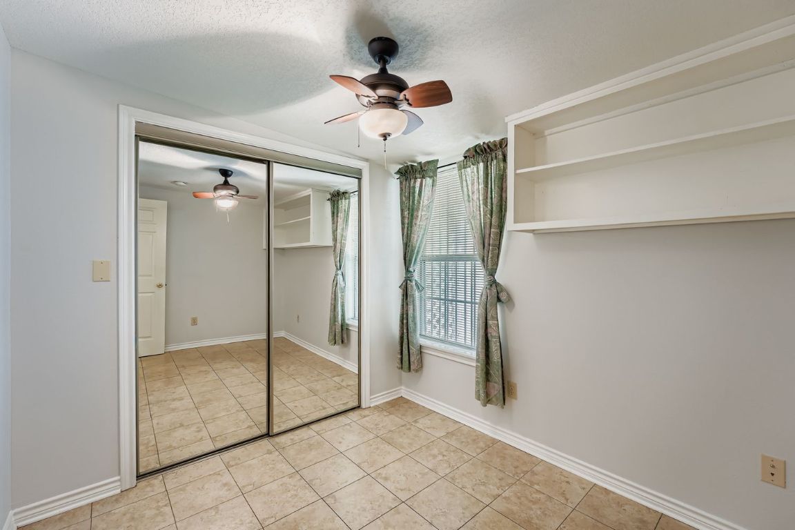 2308 Santa Rita Street Austin, TX 78702 - Photo 19 of 27 Secondary bedroom with mirrored closet doors and shelving, perfect for guests, a home office, or creative space.