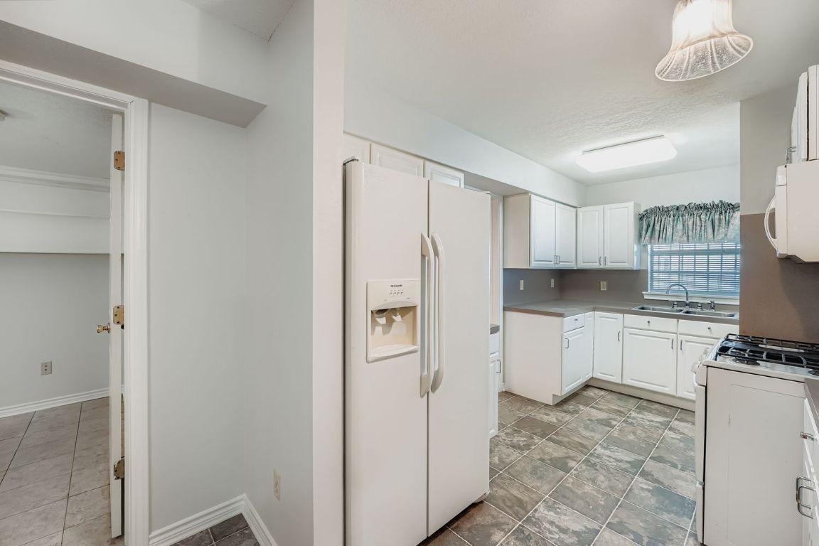 2308 Santa Rita Street Austin, TX 78702 - Photo 10 of 27 a kitchen with white cabinets and refrigerator