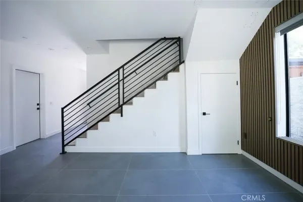 a living room with stainless steel appliances furniture a refrigerator a stove a microwave and a more window