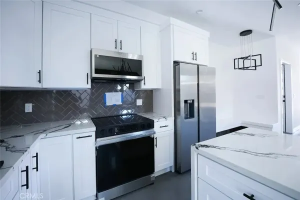a kitchen with stainless steel appliances granite countertop a refrigerator stove and microwave