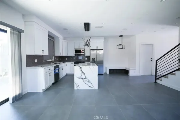 a kitchen with white cabinets and stainless steel appliances