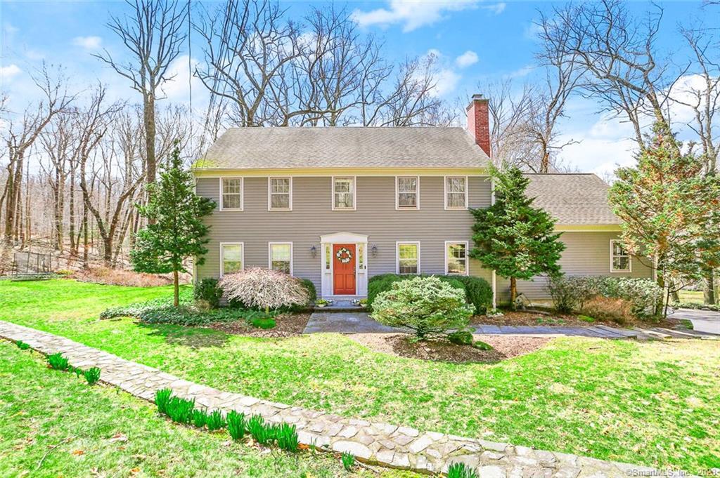 a front view of a house with a yard and potted plants