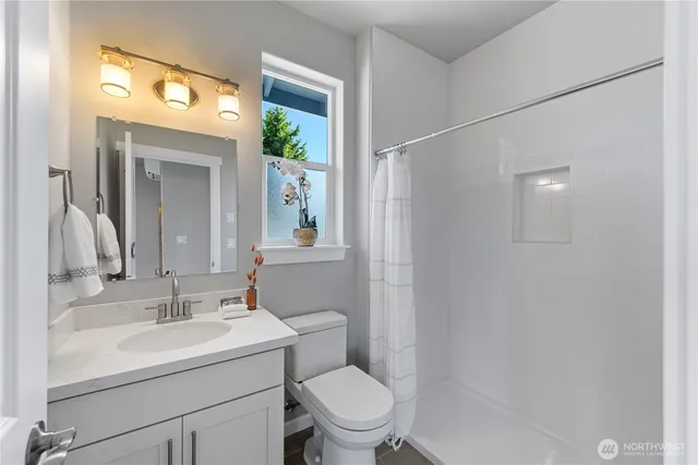 a bathroom with a sink a toilet and shower