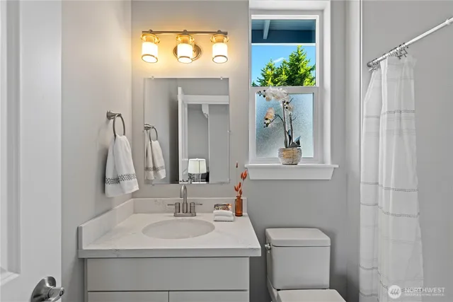 a bathroom with a sink toilet and mirror