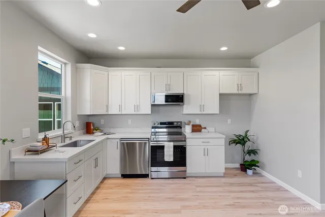 a kitchen with a white stove top oven and white cabinets