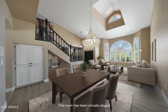 a dining room with wooden floor a chandelier a wooden table and chairs