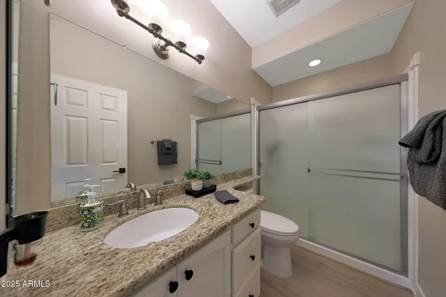 a bathroom with a granite countertop double vanity sink mirror and