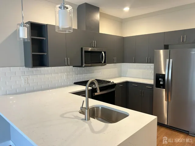 a kitchen with granite countertop a refrigerator and a stove