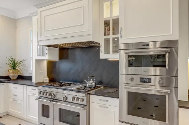 a stove top oven sitting inside of a kitchen