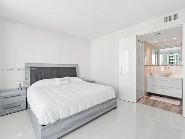 a bedroom with a bed and a view of kitchen