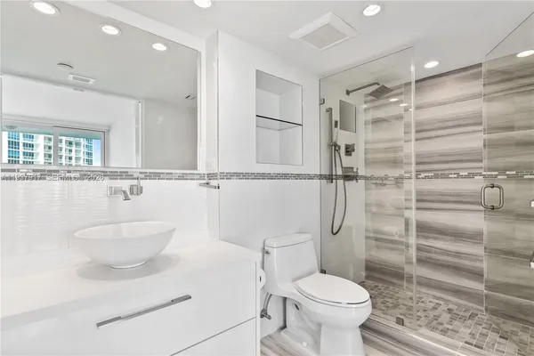 a bathroom with a toilet a sink and shower