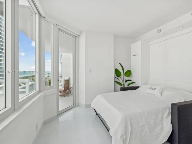 a bedroom with a bed and a large window with outer view