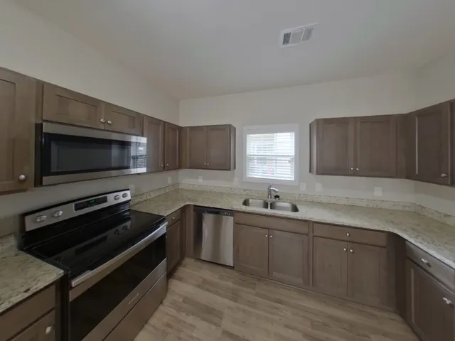 a kitchen with a sink and stainless steel appliances
