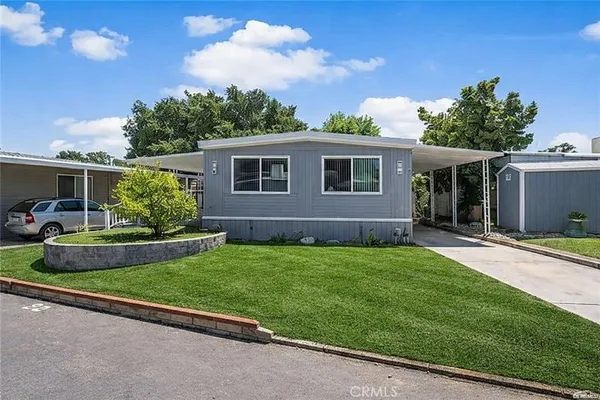 a front view of a house with a garden and yard