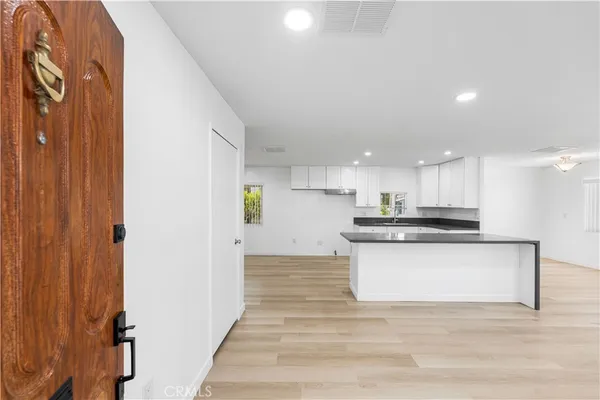 a view of kitchen with kitchen island sink and refrigerator