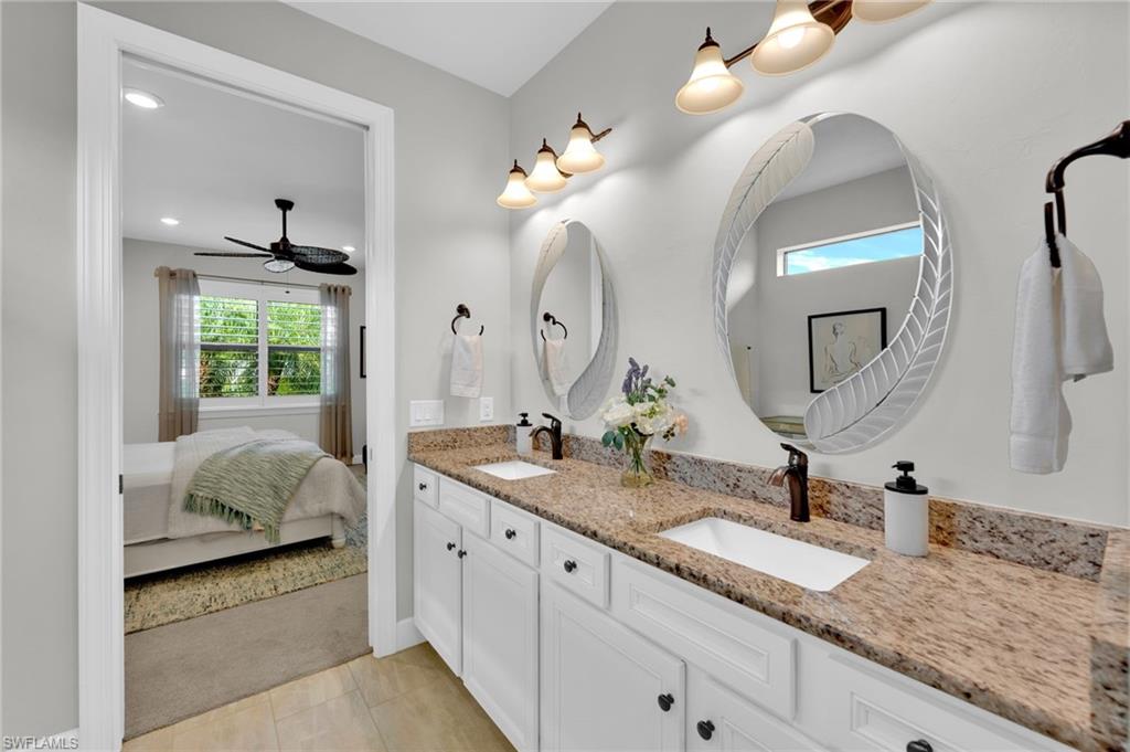19802 Bittersweet Lane Estero, FL 33928 - Photo 24 of 50 a en suite bathroom with double sink and a mirror