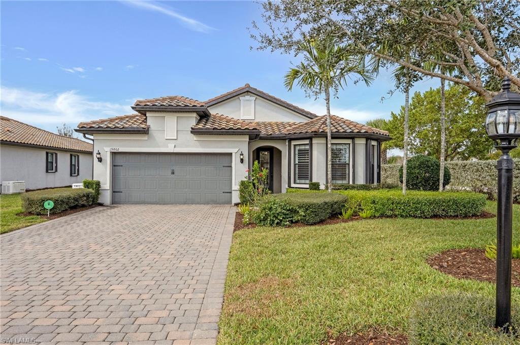 19802 Bittersweet Lane Estero, FL 33928 - Photo 41 of 50 a front view of a house with a yard and garage