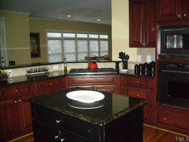 12240 Beestone Lane Raleigh, NC 27614 - Photo 8 of 12 a kitchen with granite countertop a sink and a stove