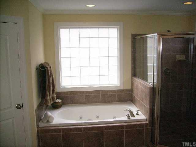 12240 Beestone Lane Raleigh, NC 27614 - Photo 10 of 12 a bath tub sitting in a bathroom next to a window