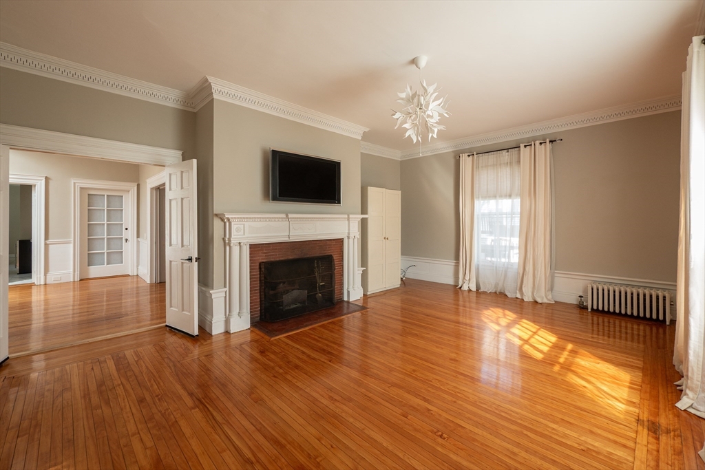 11 Wayne Street Boston, MA 02121 - Photo 7 of 27 a view of an empty room with wooden floor and a window