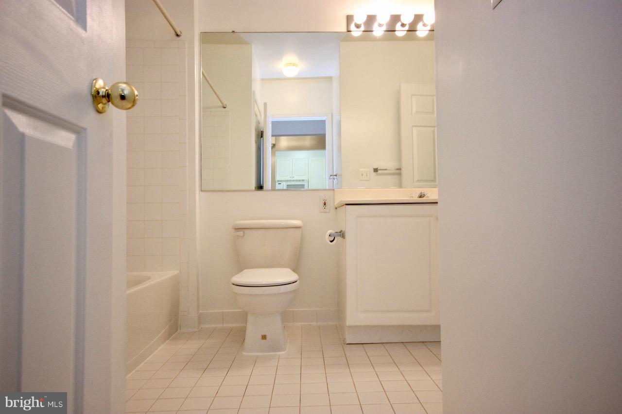 7000 Falls Reach Drive, Unit 110 Falls Church, VA 22043 - Photo 15 of 26 a bathroom with a toilet a sink and mirror