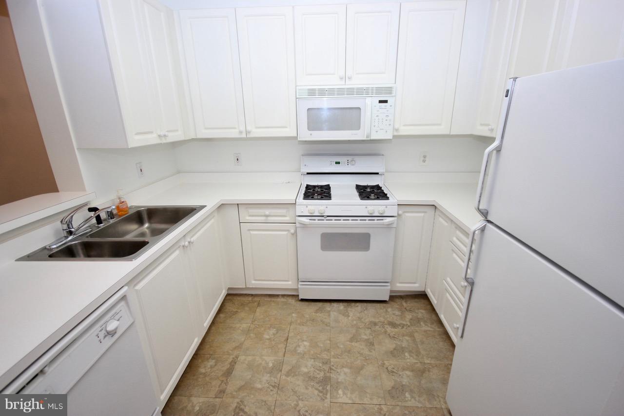 7000 Falls Reach Drive, Unit 110 Falls Church, VA 22043 - Photo 16 of 26 a kitchen with a sink a stove and cabinets