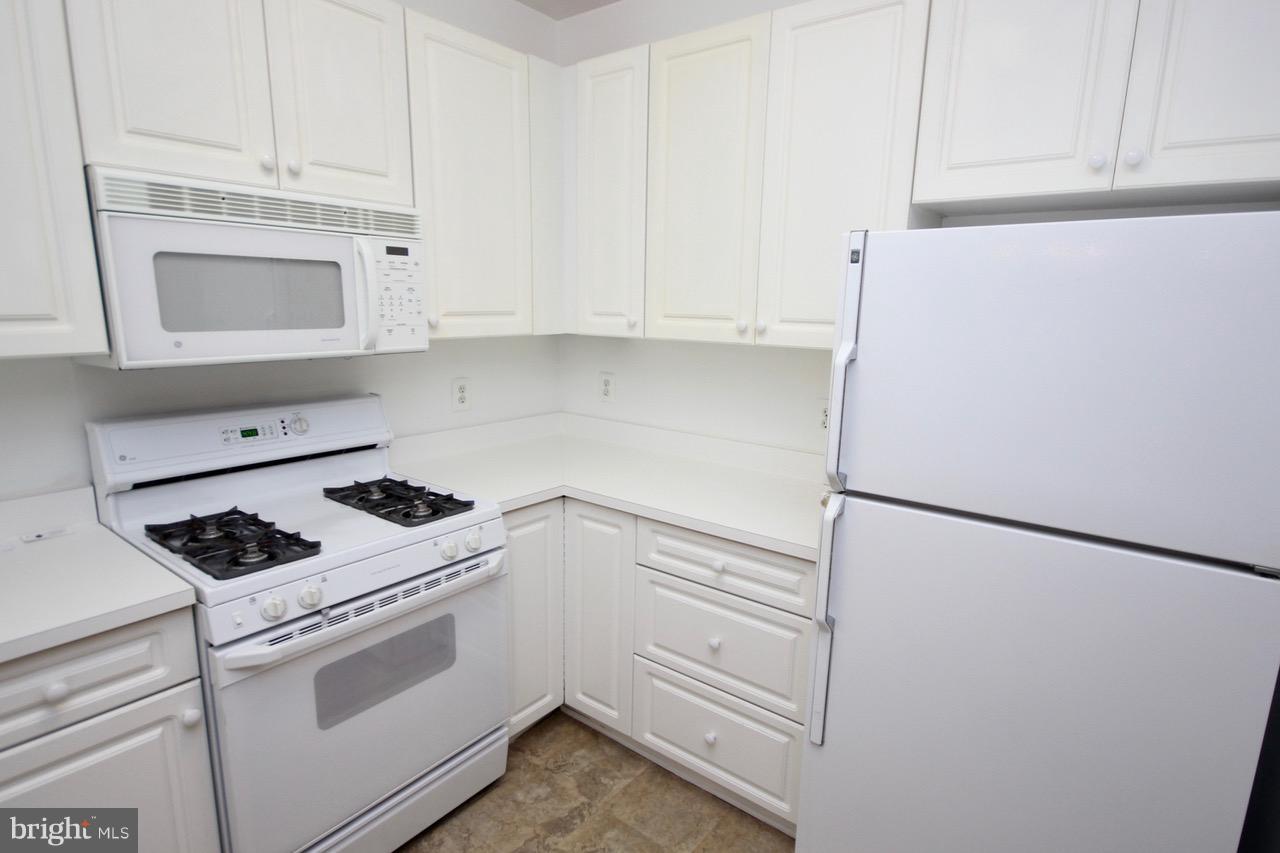 7000 Falls Reach Drive, Unit 110 Falls Church, VA 22043 - Photo 2 of 26 a kitchen with white cabinets and white appliances