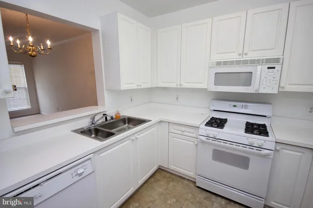 a kitchen with white cabinets and white appliances
