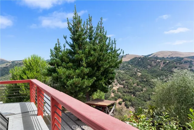 a view of a dry yard with mountains in the background