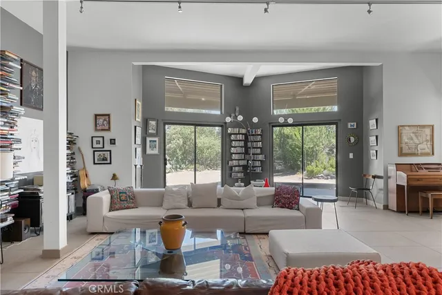 a living room with fireplace furniture and floor to ceiling window