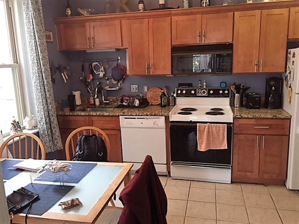 24 Ransom Road, Unit 2 Boston, MA 02135 - Photo 2 of 6 a kitchen with stainless steel appliances granite countertop a stove a sink and a microwave