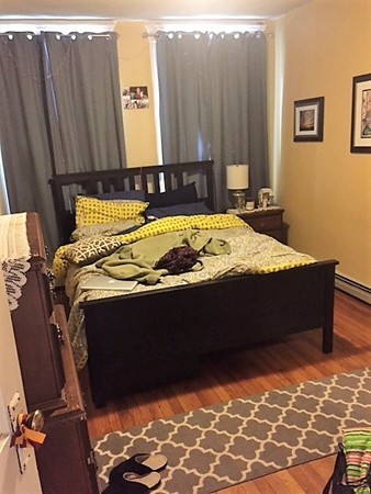 24 Ransom Road, Unit 2 Boston, MA 02135 - Photo 3 of 6 a bed sitting in a bedroom next to a cabinet