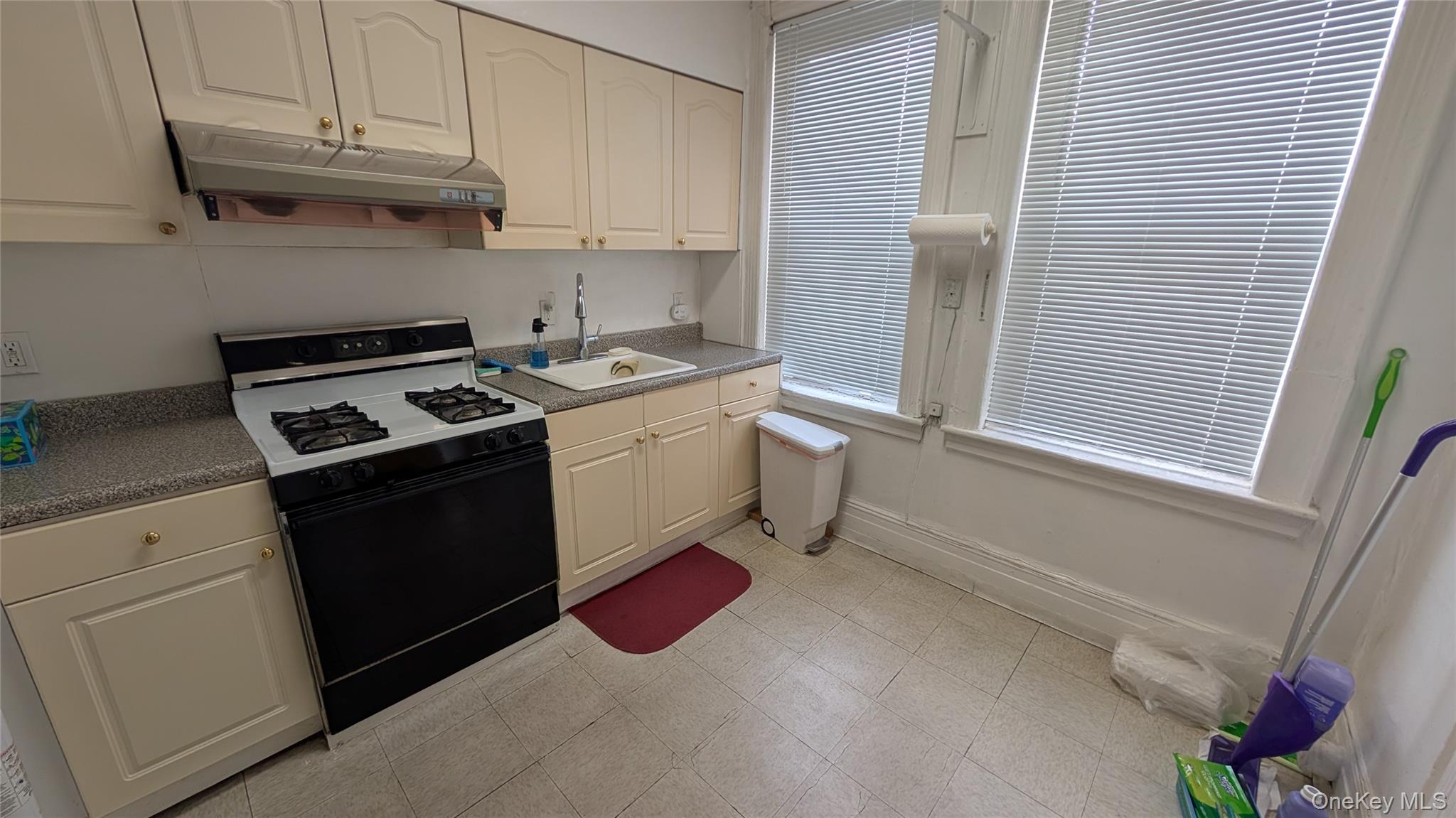 44-66 23rd Street Queens, NY 11101 - Photo 3 of 26 a kitchen with a stove and a white cabinet