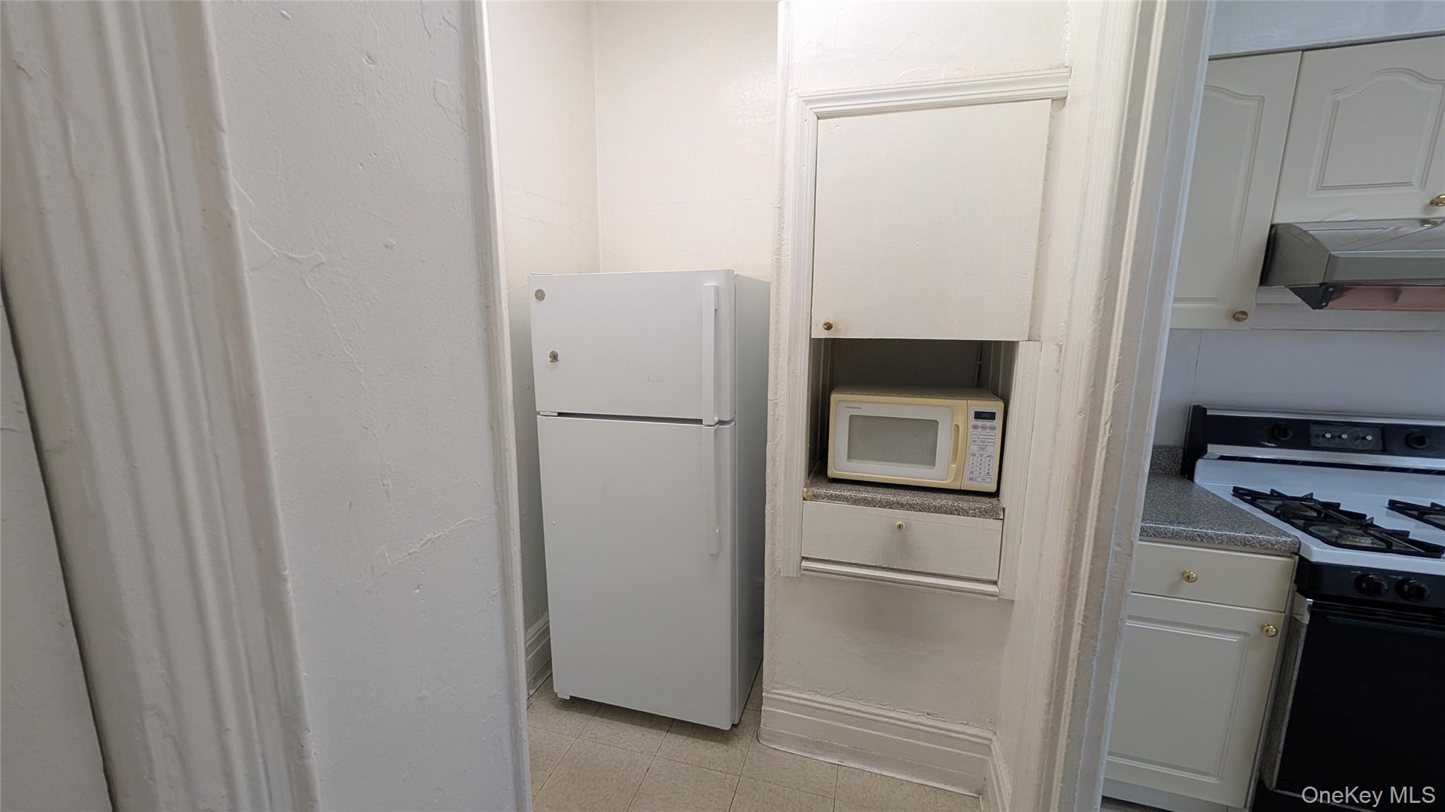 44-66 23rd Street Queens, NY 11101 - Photo 4 of 26 a kitchen with a refrigerator and a stove top oven