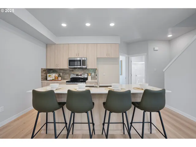 a kitchen with a dining table chairs and white appliances