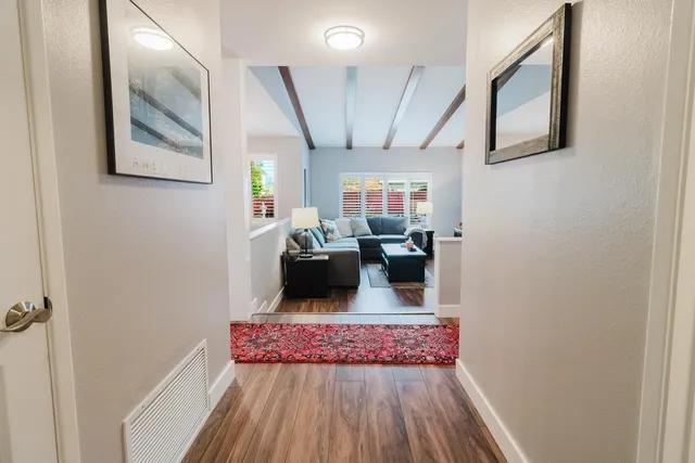 a living room with furniture a flat screen tv and a floor to ceiling window