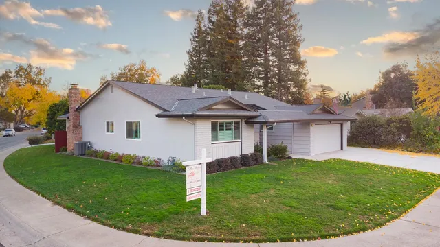 a view of a house with a yard and fence
