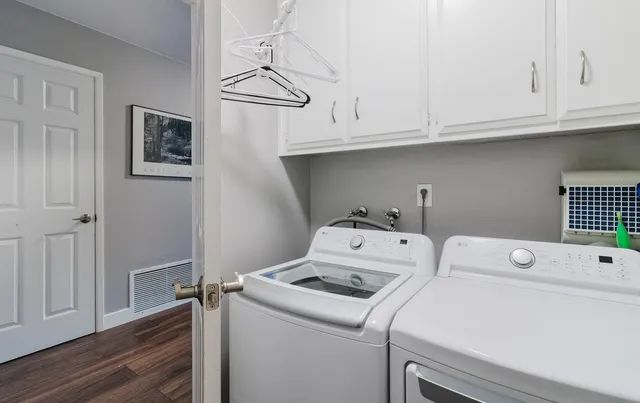 a view of washer and dryer with bathroom in the background