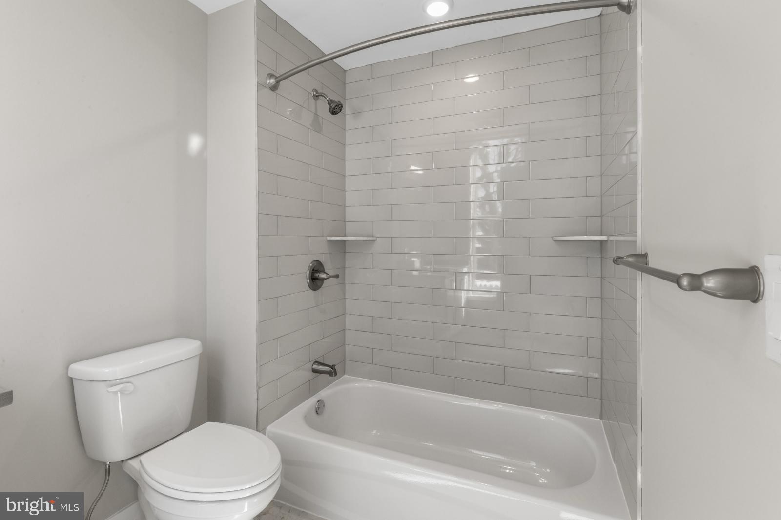 6712 Ridge Avenue, Unit 204 Philadelphia, PA 19128 - Photo 13 of 18 a white toilet sitting next to a bath tub and a shower