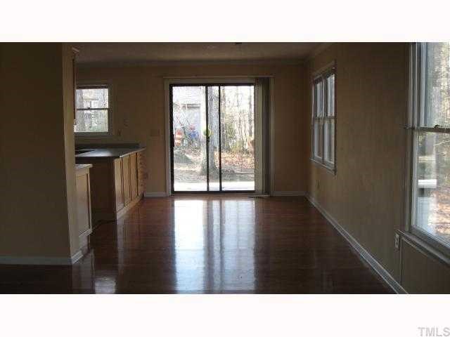 4225 Bluewing Road Raleigh, NC 27616 - Photo 6 of 8 a open hall with a floor to ceiling window and wooden floor