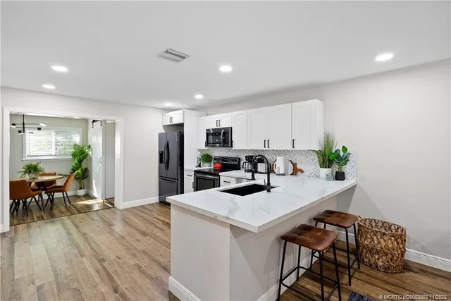 a kitchen with a table chairs refrigerator and cabinets