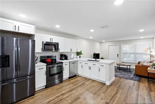 a kitchen with granite countertop appliances cabinets and a wooden floor