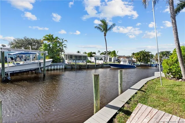 a view of a lake with a bench and trees in the background