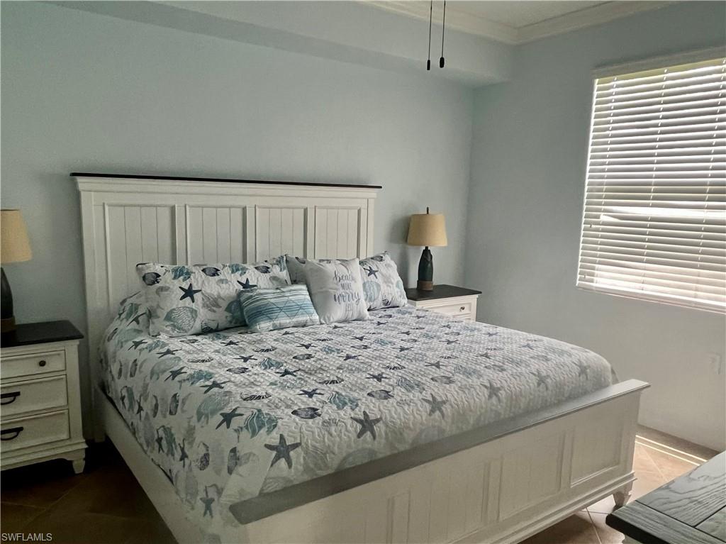 9715 Acqua Court, Unit 125 Naples, FL 34113 - Photo 16 of 24 a large bed sitting in a bedroom next to a window