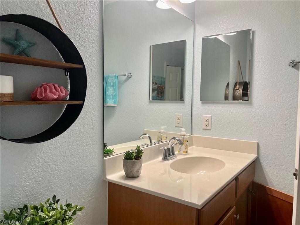 9715 Acqua Court, Unit 125 Naples, FL 34113 - Photo 24 of 24 a bathroom with a sink and a mirror