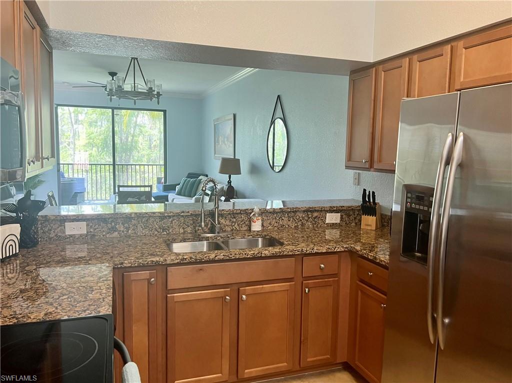 9715 Acqua Court, Unit 125 Naples, FL 34113 - Photo 4 of 24 a kitchen with stainless steel appliances granite countertop a sink stove and refrigerator