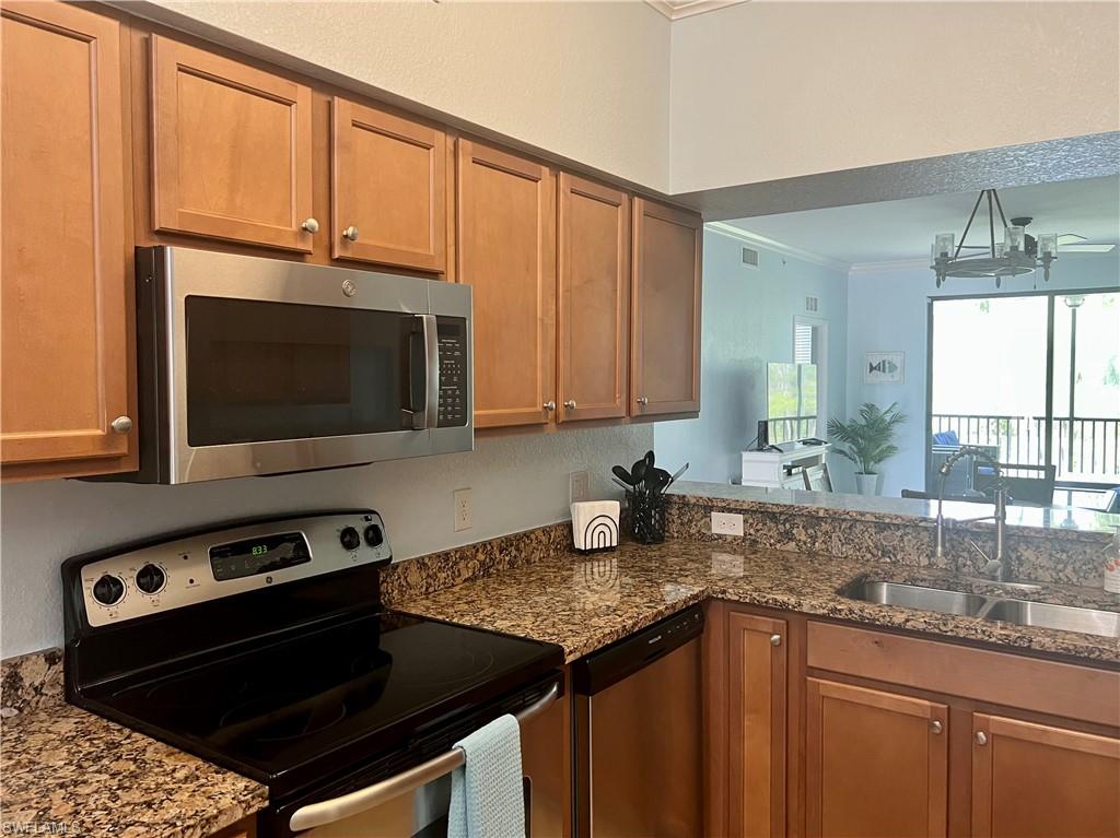 9715 Acqua Court, Unit 125 Naples, FL 34113 - Photo 5 of 24 a kitchen with granite countertop a stove sink and microwave