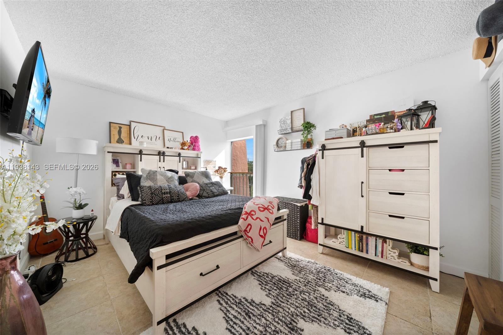 2150 Southwest 16th Avenue, Unit 402 Miami, FL 33145 - Photo 11 of 25 a bedroom with furniture and a flat screen tv