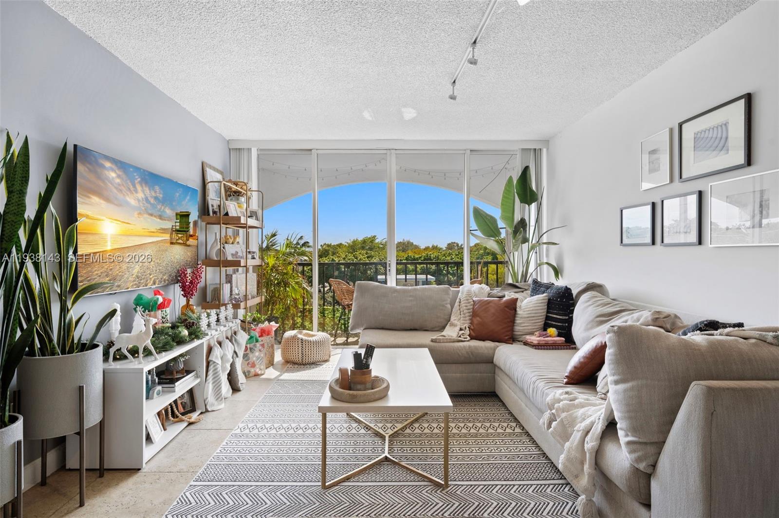 2150 Southwest 16th Avenue, Unit 402 Miami, FL 33145 - Photo 2 of 25 a living room with furniture a flat screen tv and a floor to ceiling window